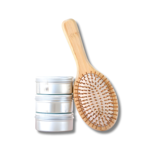 Cooki Haircare Bamboo Hair Brush with natural wooden bristles beside metal tins – eco-friendly sustainable hair care set.