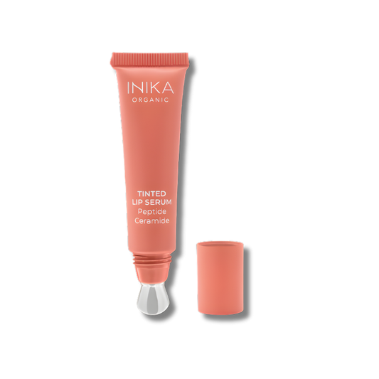 A sleek, sustainable sugarcane tube of INIKA Organic Tinted Lip Serum with a cooling metal applicator. The packaging is minimal and elegant, showing a soft natural tint inside. The product is often photographed with a light sheen on the applicator tip or swatches of sheer, glossy colour, highlighting its smooth, hydrating texture.