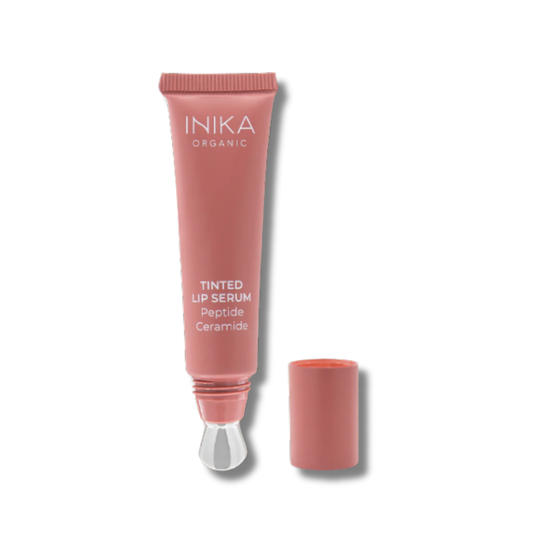 A sleek, sustainable sugarcane tube of INIKA Organic Tinted Lip Serum with a cooling metal applicator. The packaging is minimal and elegant, showing a soft natural tint inside. The product is often photographed with a light sheen on the applicator tip or swatches of sheer, glossy colour, highlighting its smooth, hydrating texture.