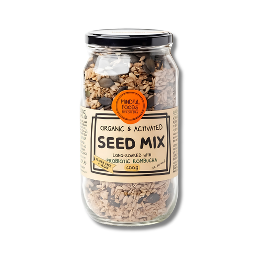 A glass jar of Mineral Foods London Organic & Activated Seed Mix, containing long-soaked grain and seed mix with visible sunflower and pumpkin seeds, topped with a black lid and a beige label.