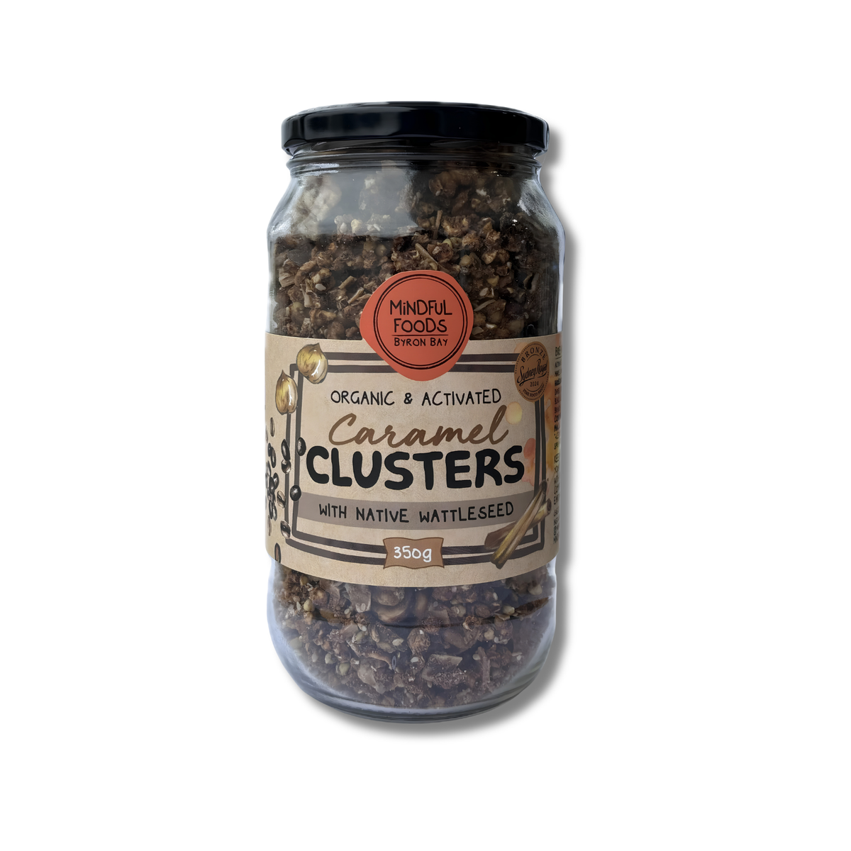 A glass jar of Mindful Foods Spelt Bay Organic & Activated Caramel Clusters, featuring a black lid and a beige label with brown and orange accents, set against a plain white background.