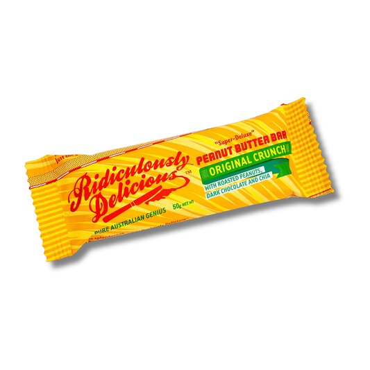 A single wrapped peanut butter bar on a plain white background. The wrapper is bright yellow with red script text reading 'Ridiculously Delicious' and additional text including 'Peanut Butter Bar', 'Original Crunch', and 'With Roasted Peanut, Dark Chocolate, and Cinnamon'.