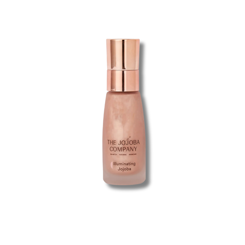 The Jojoba Company Illuminating Jojoba cosmetic bottle with a metallic rose gold cap and a pearlescent light beige liquid inside, set against a plain white background.