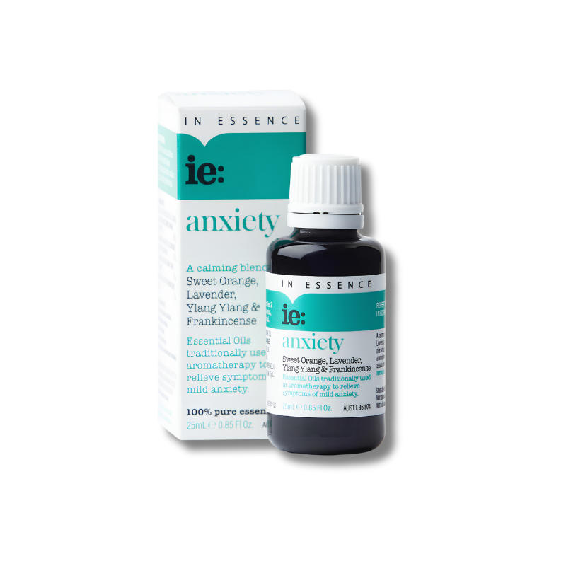 A bottle of ie: anxiety essential oil next to its retail box, featuring a dark amber glass bottle with a white cap and a white box with teal accents.