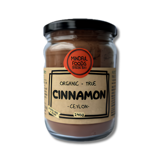 A glass jar of Mindful Foods Organic True Cinnamon (Ceylon) spice mix, featuring a black lid and a beige label with black text, set against a plain white background.