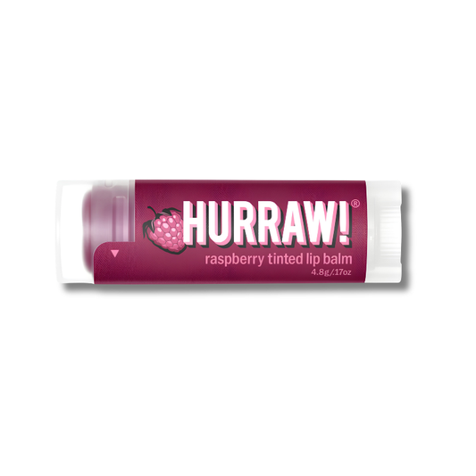 A tube of Hurraw! Raspberry Tinted Lip Balm with a dark magenta label and white cap, shown on a plain white background.