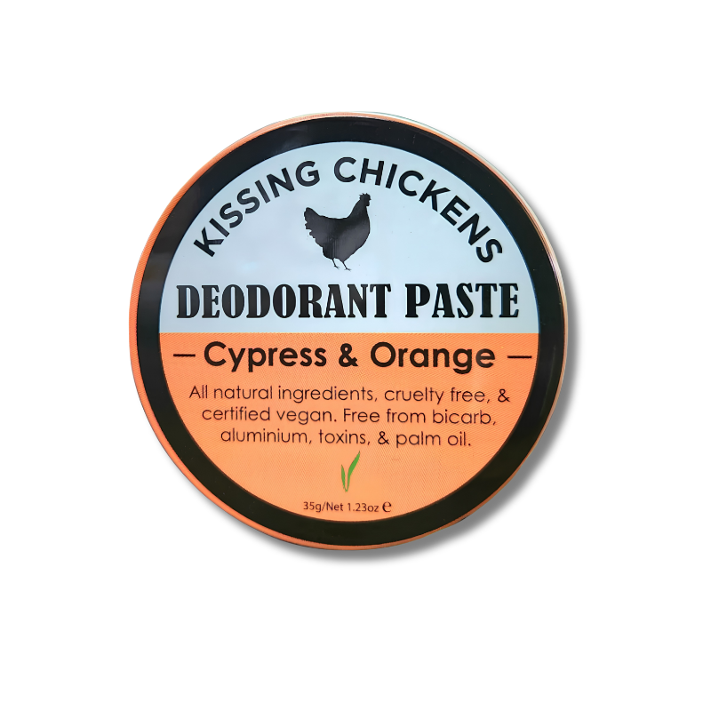 A round tin of Kissing Chickens Deodorant Paste in the Cypress & Orange scent, featuring a light blue and orange label with a black chicken silhouette.