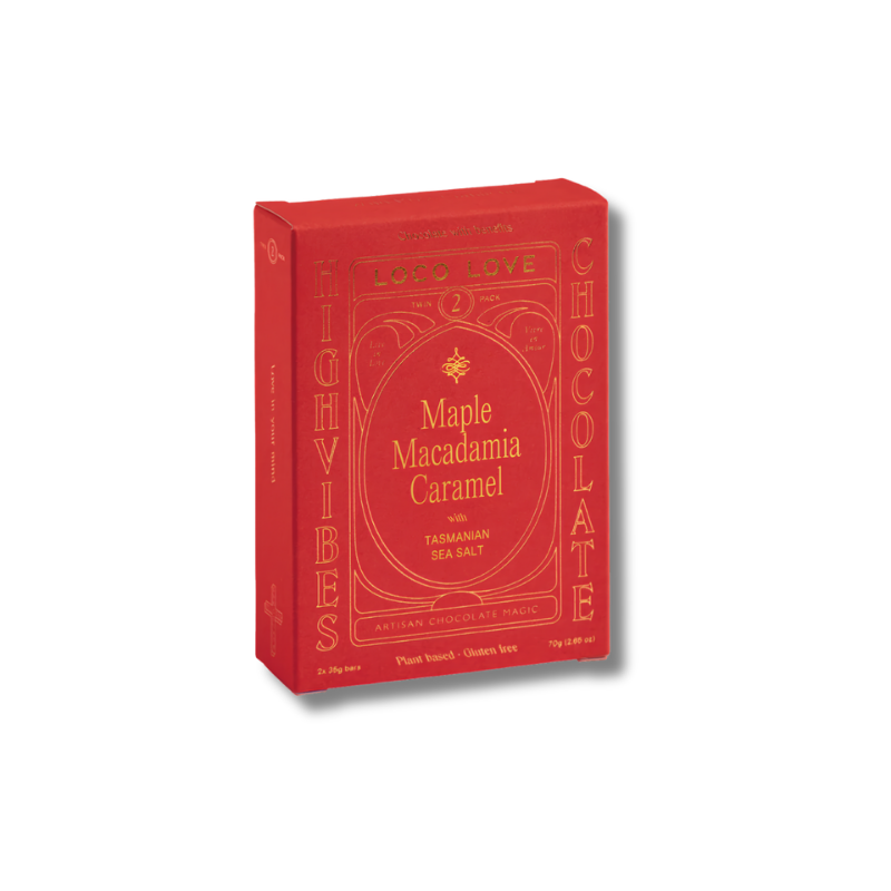 A red rectangular chocolate box with gold lettering, shown at a slight angle on a white background. The front reads 'LOVE' and 'CHOCOLATE' vertically, with 'Maple Macadamia Caramel' in the center.
