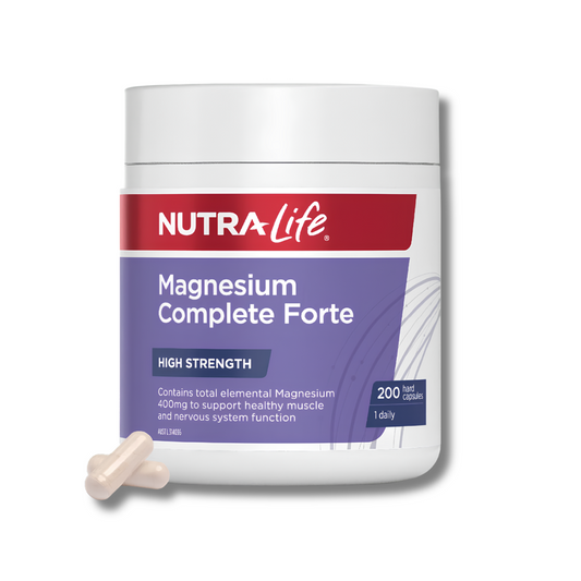 A white plastic bottle of NutraLife Magnesium Complete Forte dietary supplement with a red and purple label, shown on a white background with two beige capsules in the foreground.