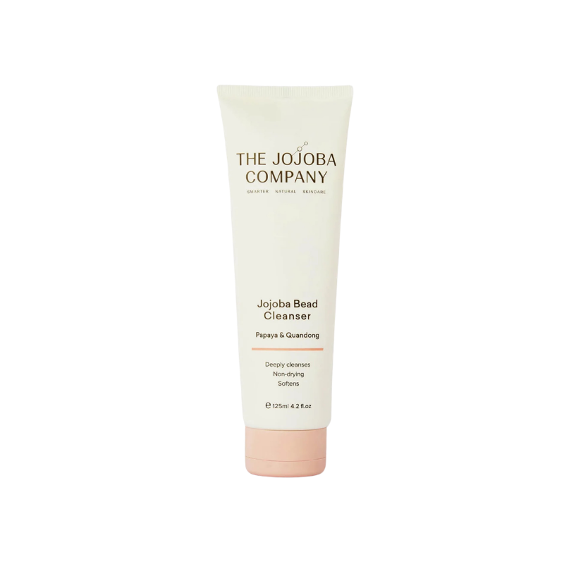 A 120ml squeeze tube of The Jojoba Company Jojoba Bead Cleanser on a solid white background. The tube is off-white with black text and a light pink cap.